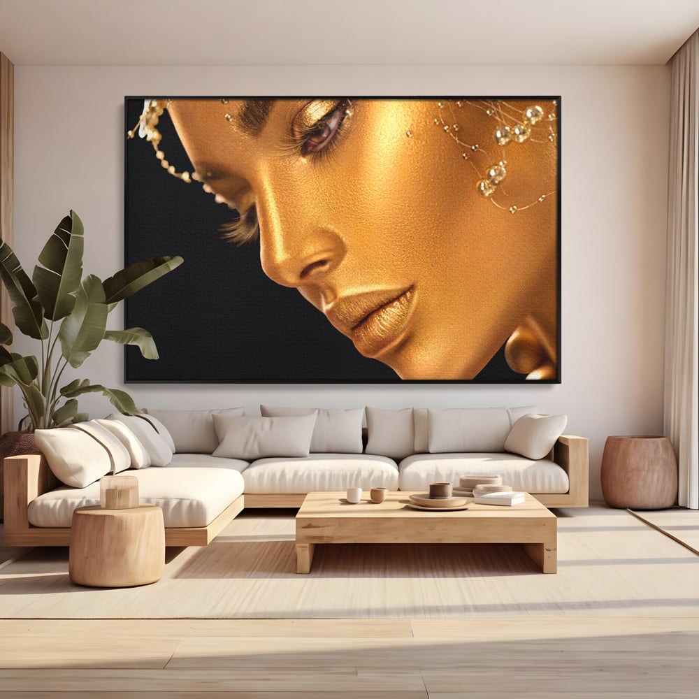 Tablou canvas cu tablou canvas cu femeie in nuante aurii, in rama de aluminiu negru, pe perete intr-un living