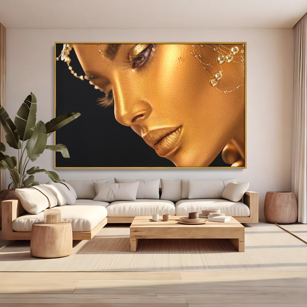 Tablou canvas cu tablou canvas cu femeie in nuante aurii, in rama de aluminiu auriu, pe perete intr-un living