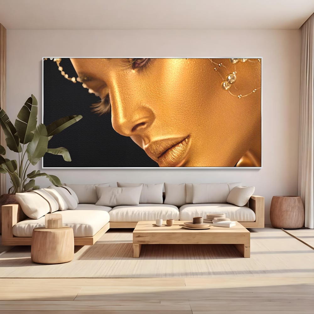 Tablou canvas cu tablou canvas cu femeie in nuante aurii, in rama de aluminiu argintiu, pe perete intr-un living
