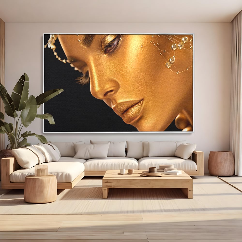 Tablou canvas cu tablou canvas cu femeie in nuante aurii, in rama de aluminiu argintiu, pe perete intr-un living