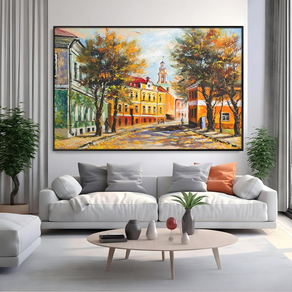 Tablou canvas cu pictura stradala cu peisaj de toamna, in rama de aluminiu negru, pe perete intr-un living