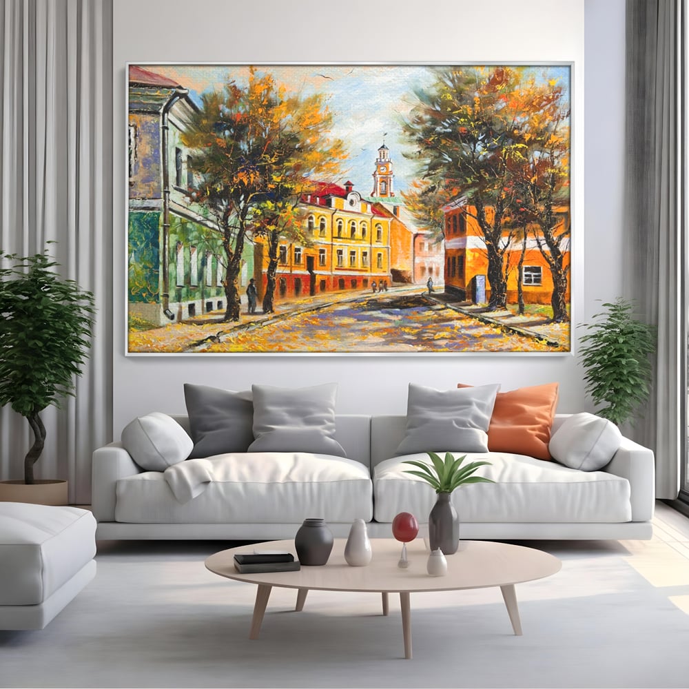 Tablou canvas cu pictura stradala cu peisaj de toamna, in rama de aluminiu argintiu, pe perete intr-un living