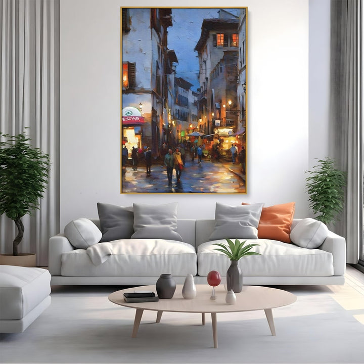 Tablou canvas cu pictura stradala cu oameni seara, in rama de aluminiu auriu, pe perete intr-un living