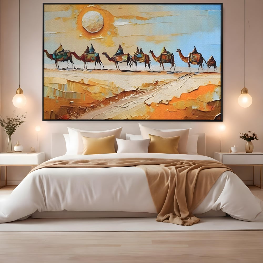 Tablou canvas cu pictura cu caravana de camile in desert, in rama de aluminiu negru, pe perete intr-un dormitor