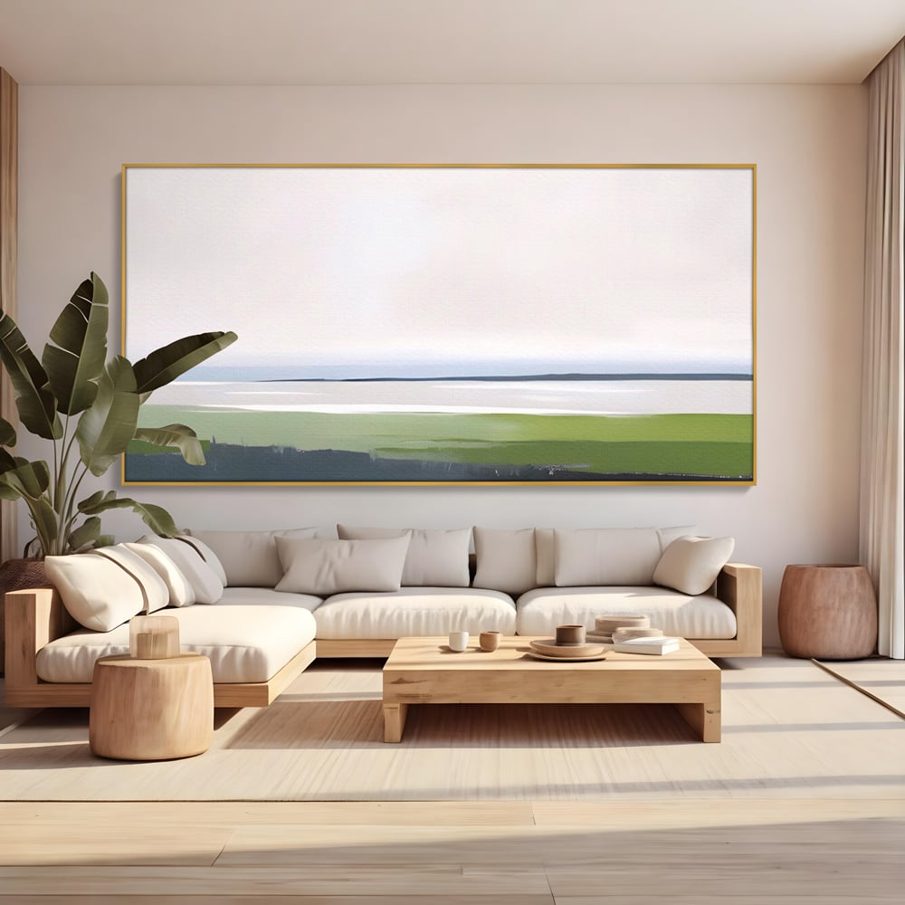 Tablou canvas cu pictura orizontala cu peisaj de campie si apa, in rama de aluminiu auriu, pe perete intr-un living