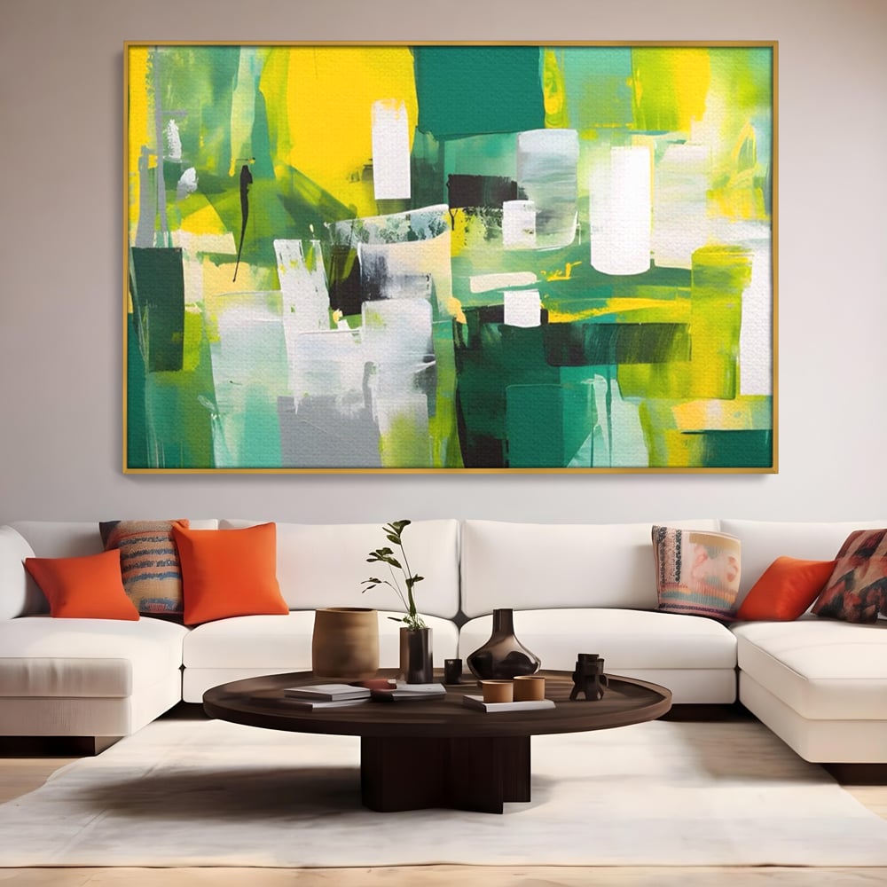 Tablou canvas cu pictura abstracta cu pete verzi si galbene, in rama de aluminiu auriu, pe perete intr-un living
