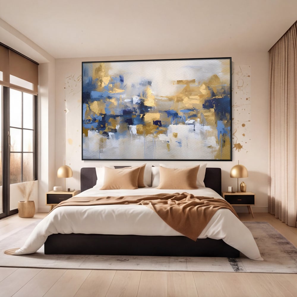 Tablou canvas cu tablou abstract cu pete aurii si albastre, in rama de aluminiu negru, pe perete intr-un dormitor