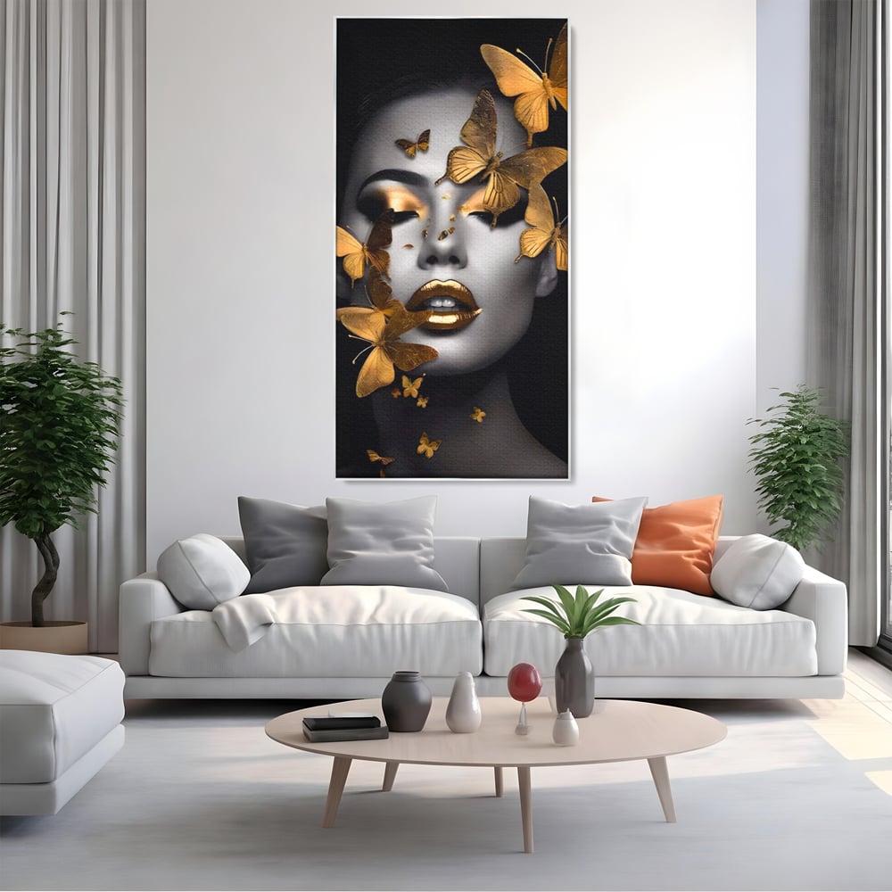 Tablou canvas cu tablou canvas cu portret de femeie si fluturi aurii, in rama de aluminiu argintiu, pe perete intr-un living