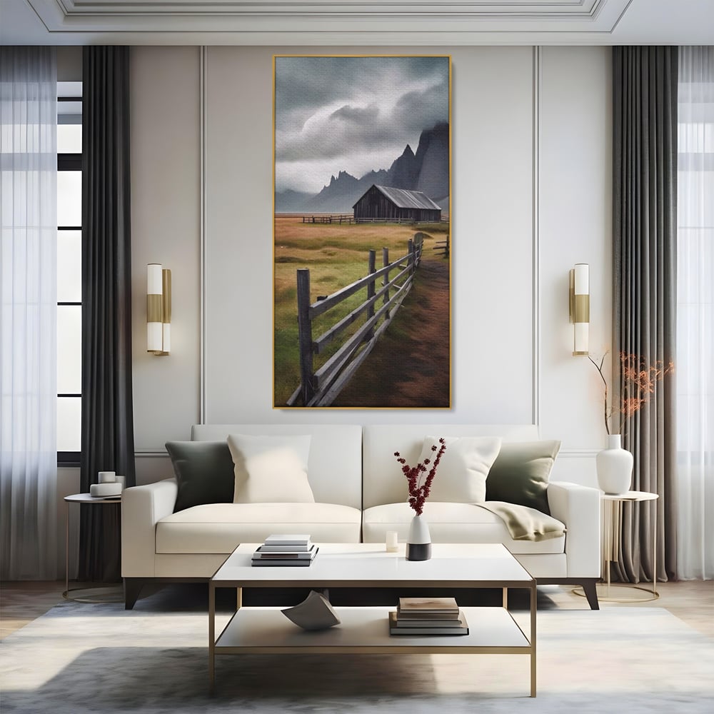 Tablou canvas cu tablou cu peisaj montan si gard de lemn, in rama de aluminiu auriu, pe perete intr-un living