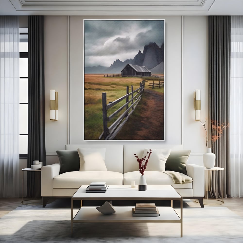 Tablou canvas cu tablou cu peisaj montan si gard de lemn, in rama de aluminiu argintiu, pe perete intr-un living