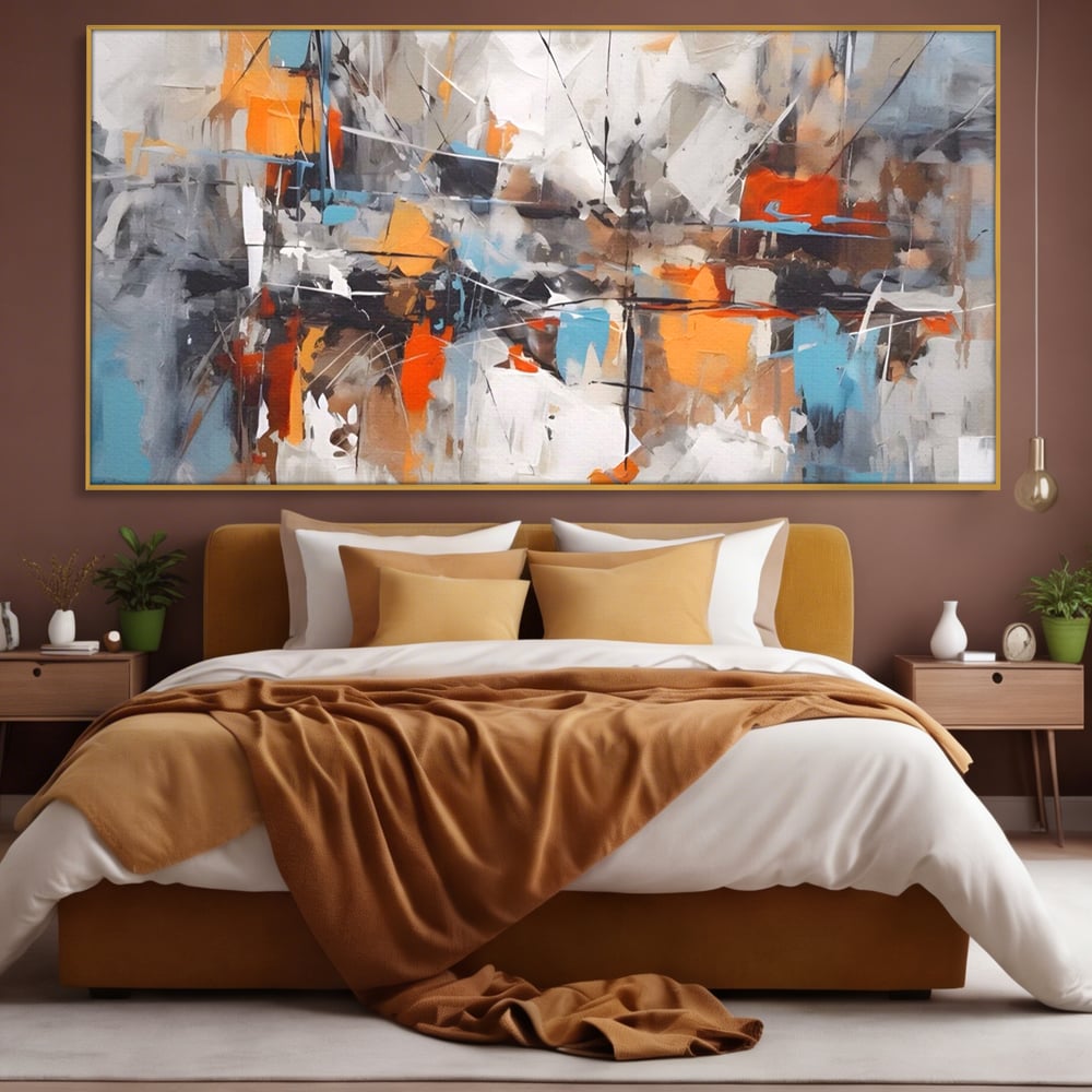 Tablou canvas cu pictura abstracta cu pete portocalii, in rama de aluminiu auriu, pe perete intr-un dormitor