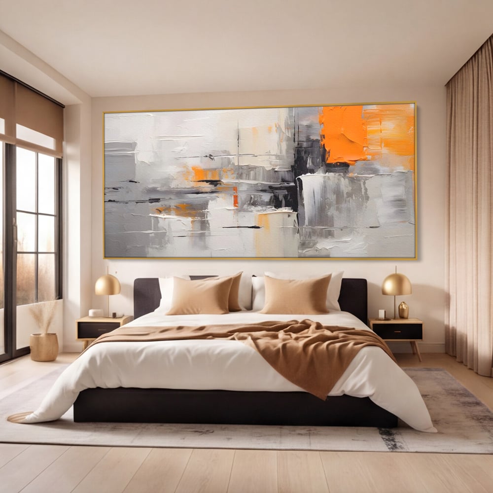 Tablou canvas cu pictura abstracta gri cu pata portocalie, in rama de aluminiu auriu, pe perete intr-un dormitor