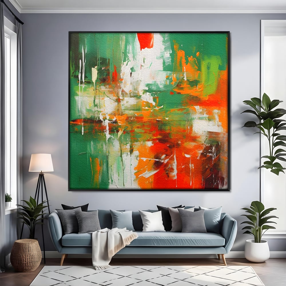 Tablou canvas cu pictura abstracta cu verde si portocaliu, in rama de aluminiu negru, pe perete intr-un living