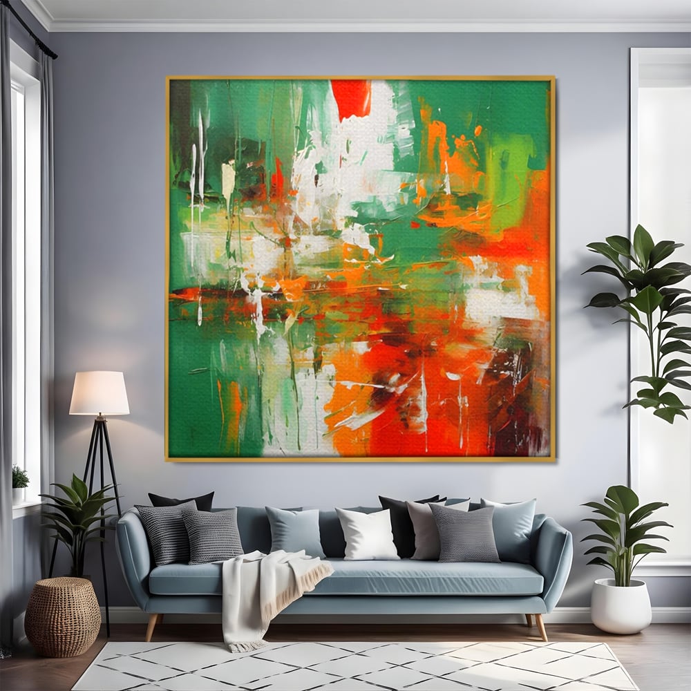 Tablou canvas cu pictura abstracta cu verde si portocaliu, in rama de aluminiu auriu, pe perete intr-un living