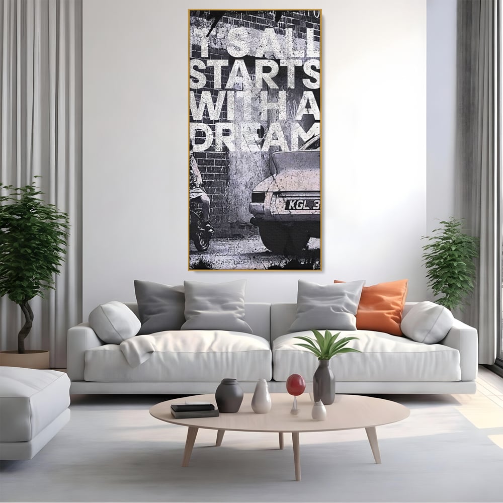 Tablou canvas cu tablou motivational alb-negru cu text si masina, in rama de aluminiu auriu, pe perete intr-un living