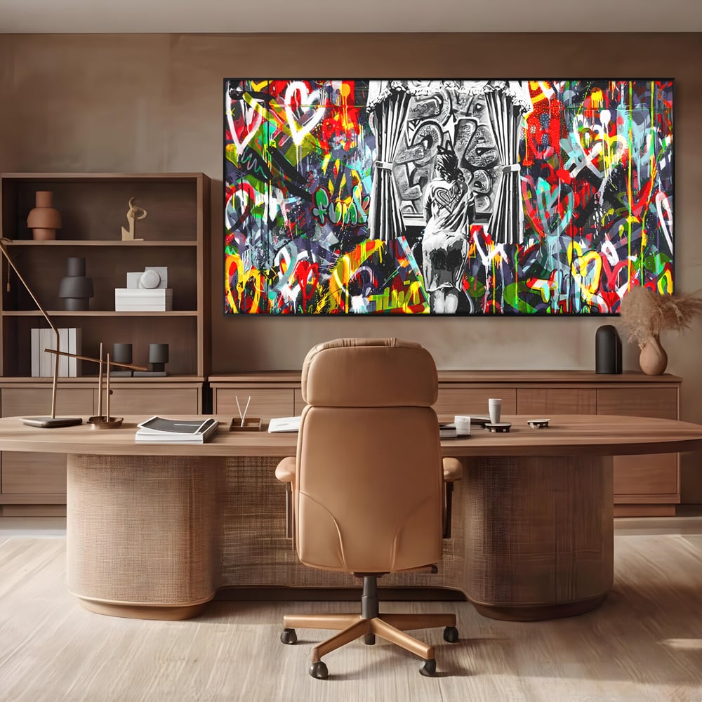 Tablou canvas cu tablou canvas cu graffiti urban si o silueta, in rama de aluminiu negru, pe perete intr-un birou