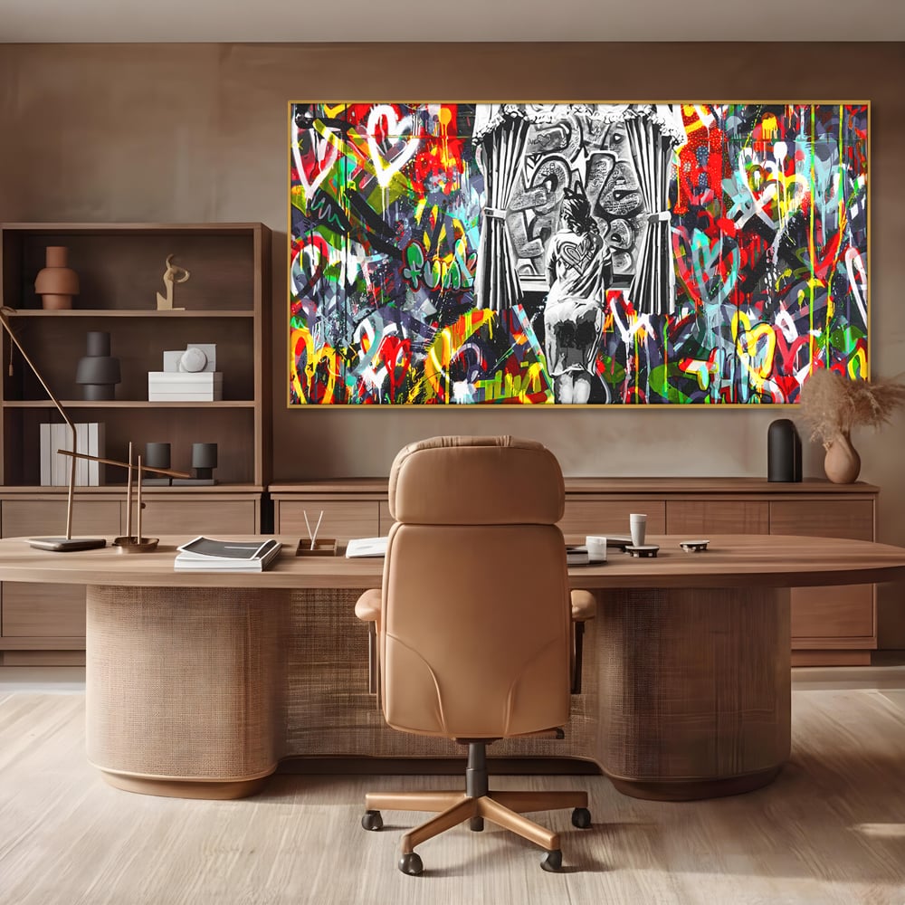 Tablou canvas cu tablou canvas cu graffiti urban si o silueta, in rama de aluminiu auriu, pe perete intr-un birou