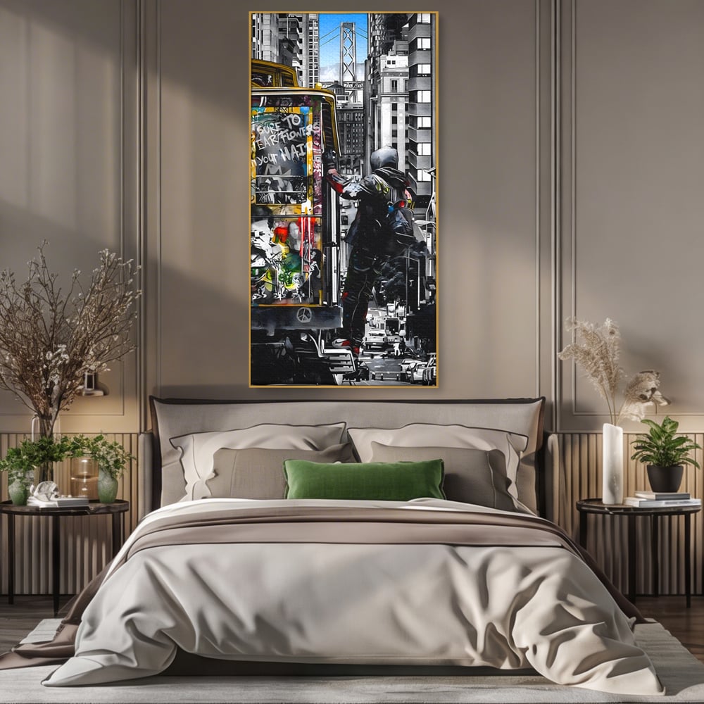 Tablou canvas cu ilustratie urbana cu un tramvai si un calator, in rama de aluminiu auriu, pe perete intr-un dormitor