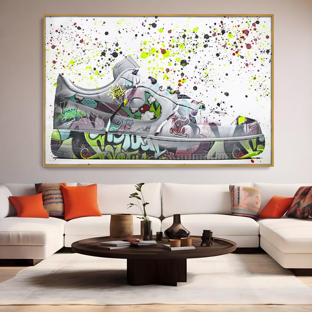 Tablou canvas cu tablou canvas cu adidasi graffiti, in rama de aluminiu auriu, pe perete intr-un living