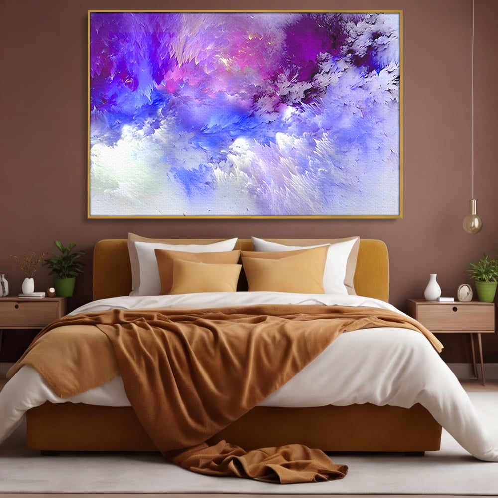 Tablou canvas cu pictura abstracta cu nori mov si albastri, in rama de aluminiu auriu, pe perete intr-un dormitor