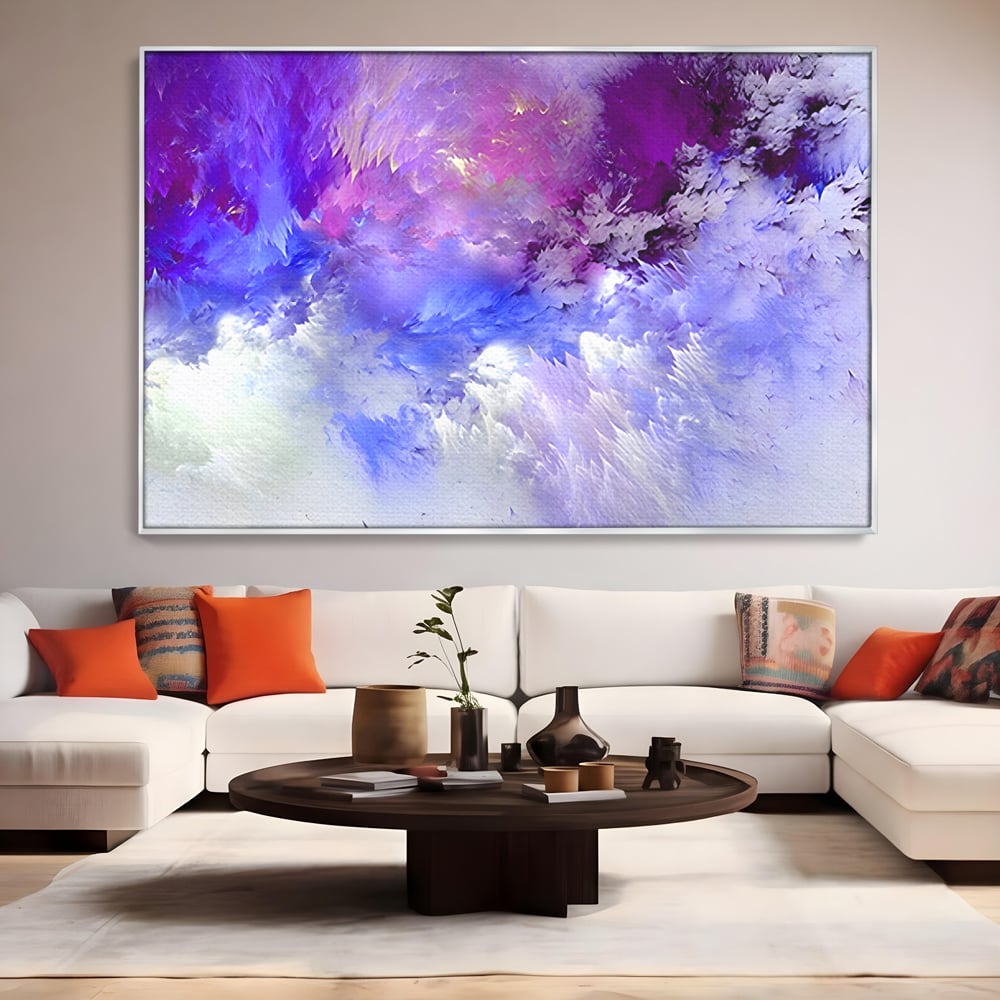 Tablou canvas cu pictura abstracta cu nori mov si albastri, in rama de aluminiu argintiu, pe perete intr-un living