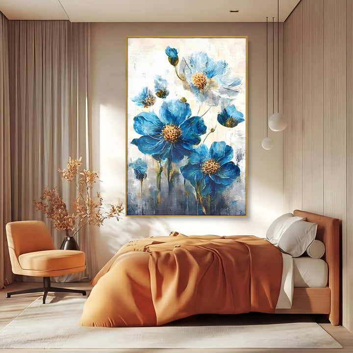 Tablou canvas cu pictura verticala cu flori albastre, in rama de aluminiu auriu, pe perete intr-un dormitor