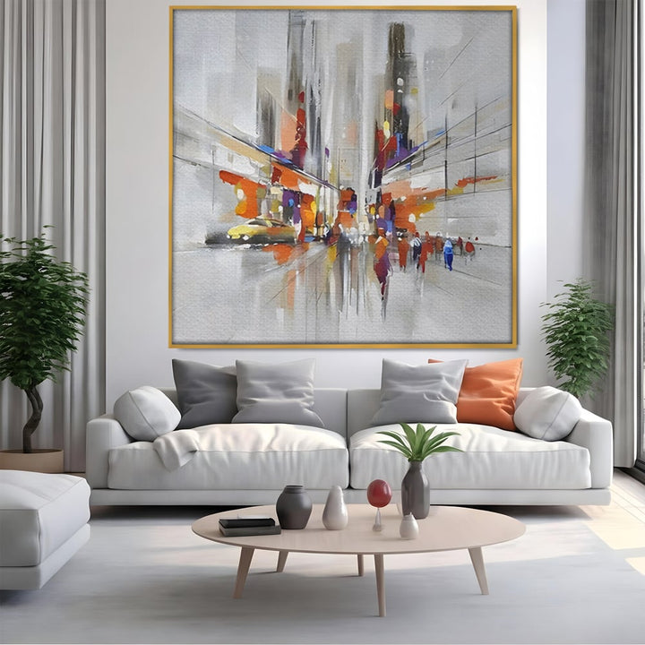 Tablou canvas cu pictura abstracta cu peisaj urban, in rama de aluminiu auriu, pe perete intr-un living