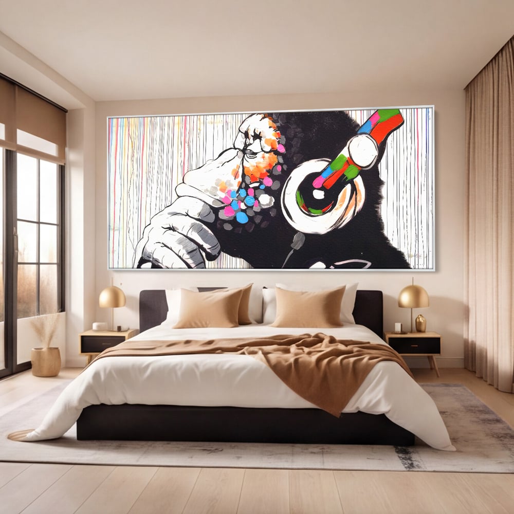 Tablou canvas cu tablou canvas cu maimuta dj, in rama de aluminiu argintiu, pe perete intr-un dormitor