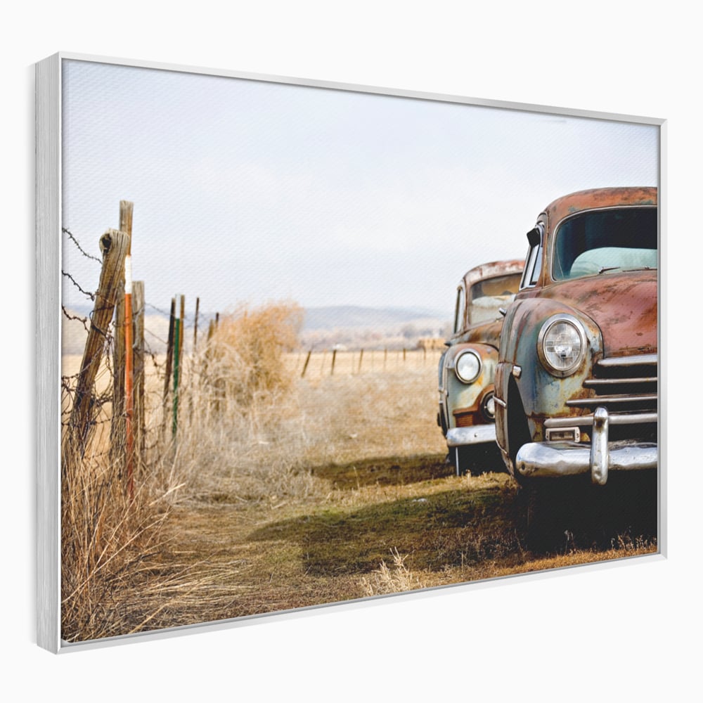 Tablou canvas cu doua masini ruginite pe un camp uscat, in rama de aluminiu argintiu