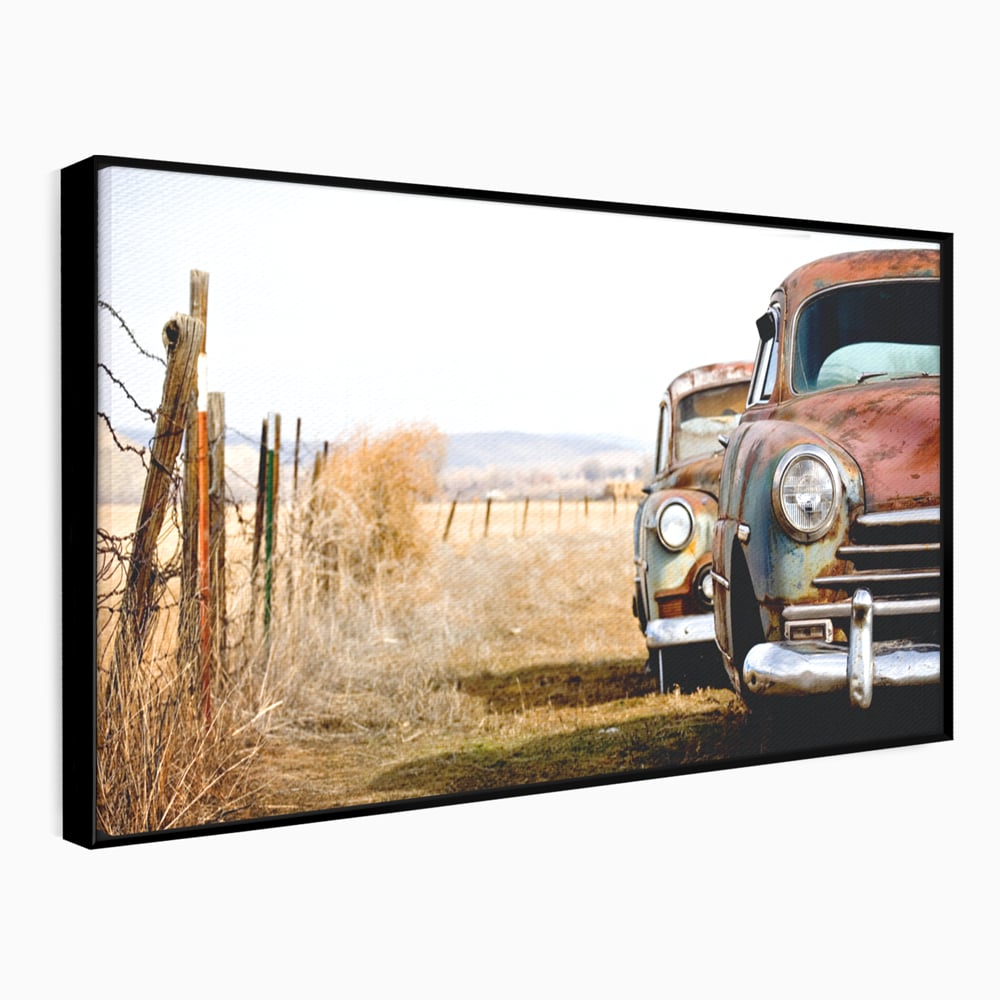 Tablou canvas cu doua masini ruginite pe un camp uscat, in rama de aluminiu negru