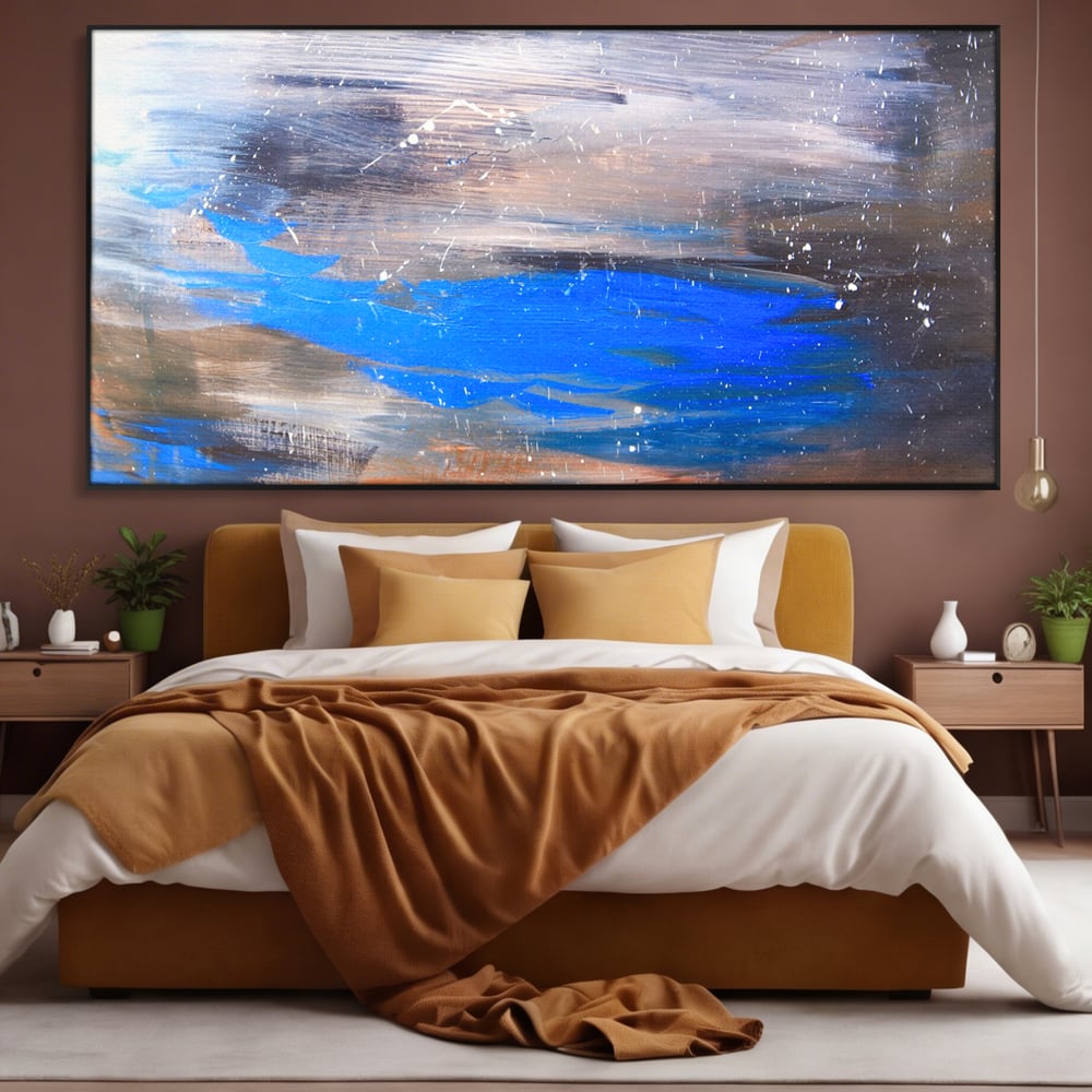 Tablou canvas cu pictura abstracta cu pete albastre, in rama de aluminiu negru, pe perete intr-un dormitor