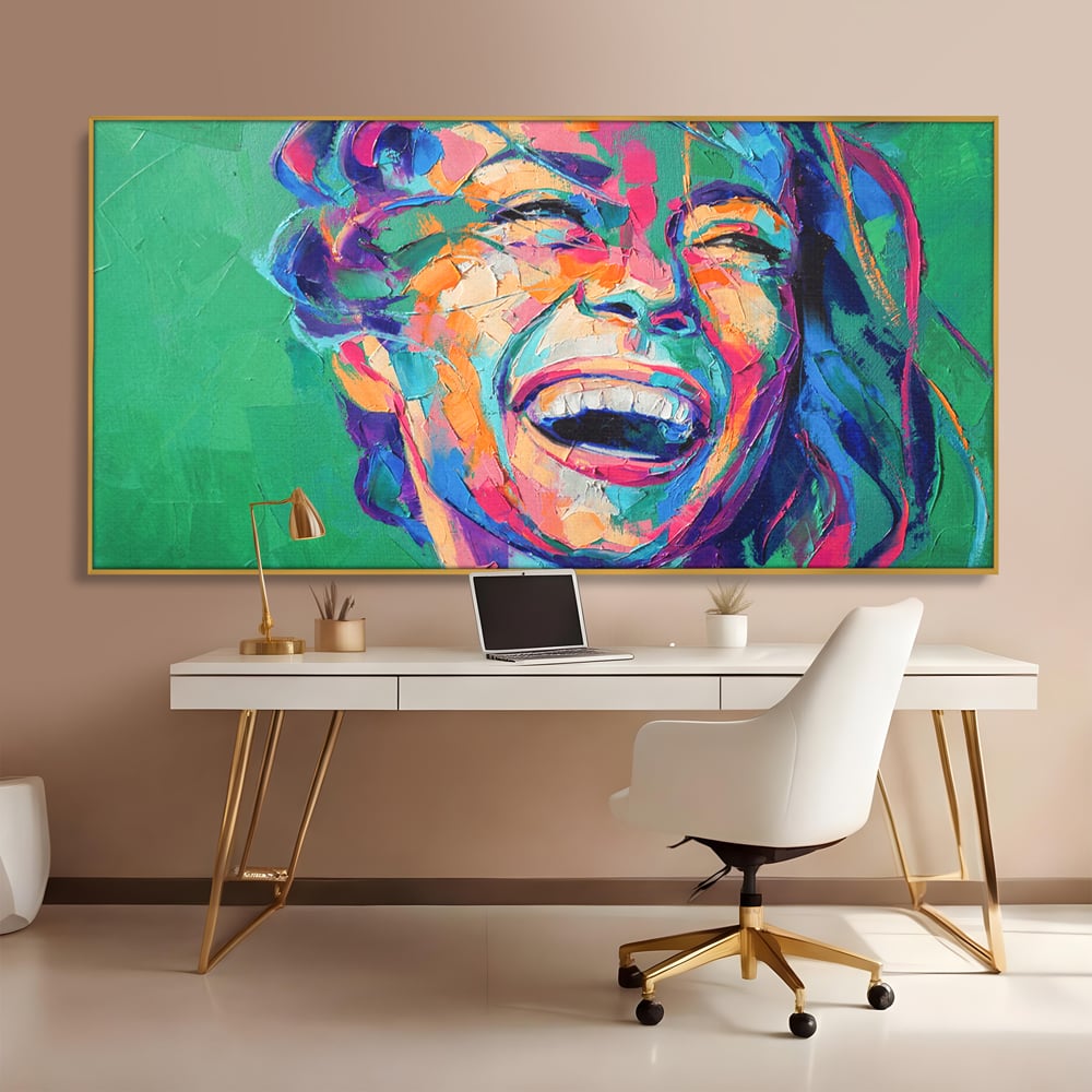 Tablou canvas cu tablou canvas cu fata zambind colorata, in rama de aluminiu auriu, pe perete intr-un birou