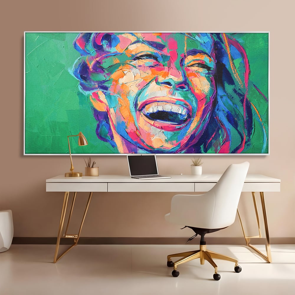 Tablou canvas cu tablou canvas cu fata zambind colorata, in rama de aluminiu argintiu, pe perete intr-un birou