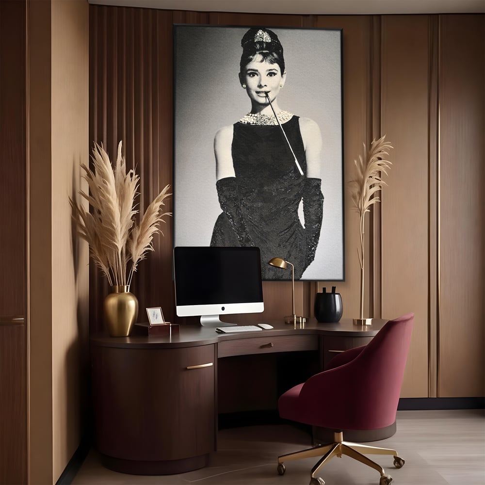 Tablou canvas cu tablou portret audrey hepburn cu tigara, in rama de aluminiu negru, pe perete intr-un birou