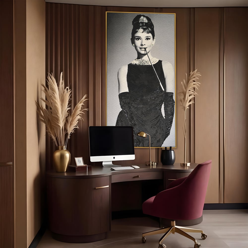 Tablou canvas cu tablou portret audrey hepburn cu tigara, in rama de aluminiu auriu, pe perete intr-un birou