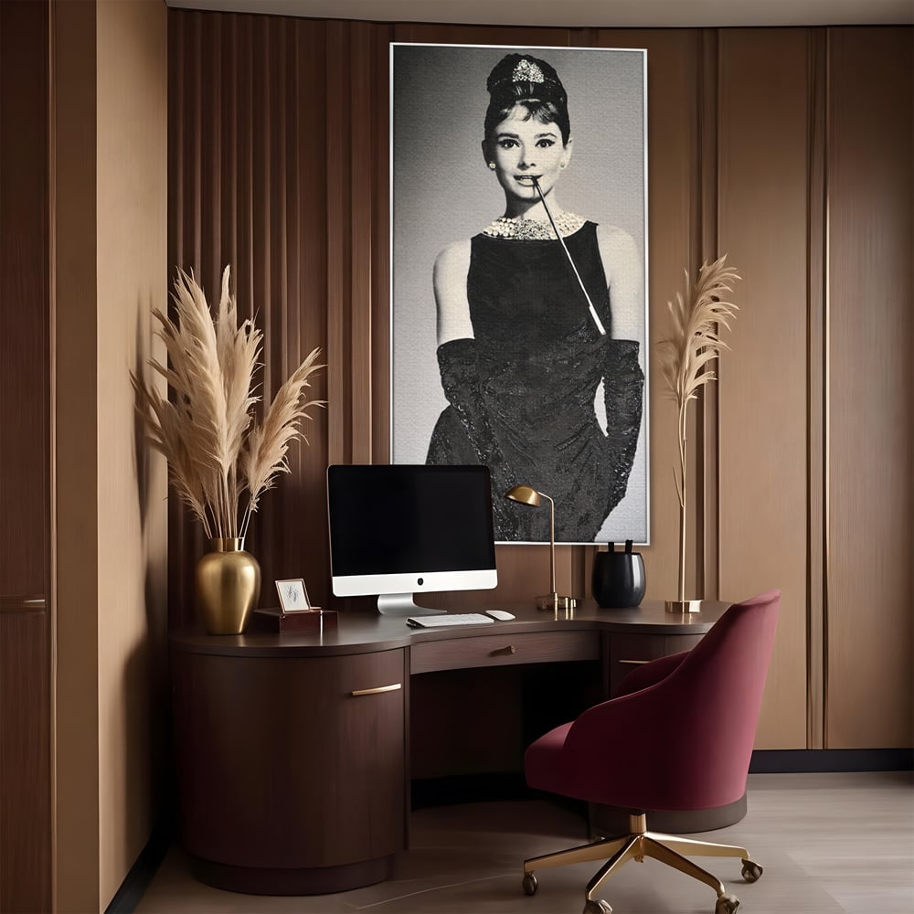 Tablou canvas cu tablou portret audrey hepburn cu tigara, in rama de aluminiu argintiu, pe perete intr-un birou