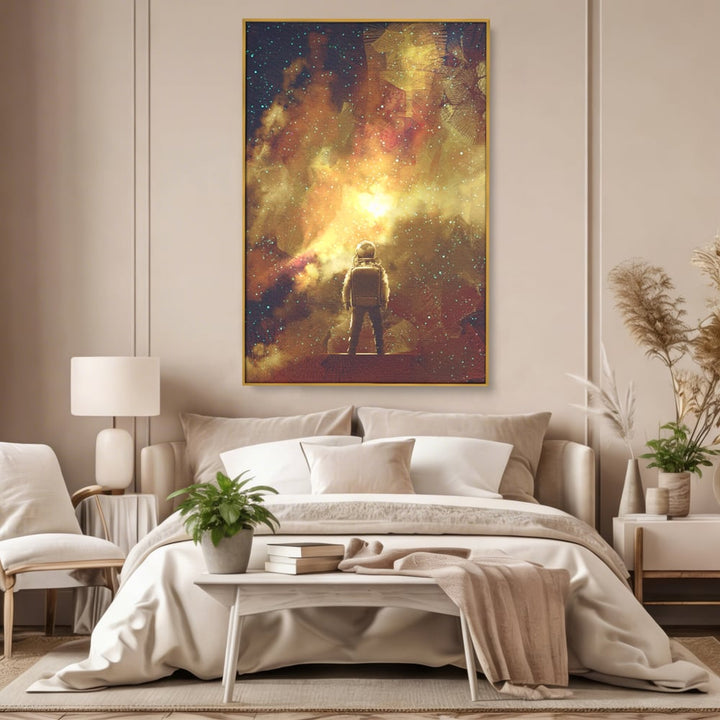 Tablou canvas cu ilustratie cu astronaut privind stelele, in rama de aluminiu auriu, pe perete intr-un dormitor