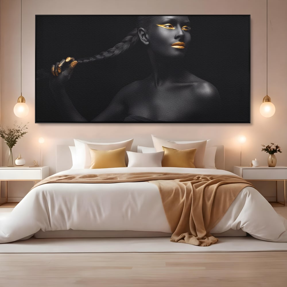 Tablou canvas cu tablou canvas cu femeie vopsita in negru si auriu, in rama de aluminiu negru, pe perete intr-un dormitor