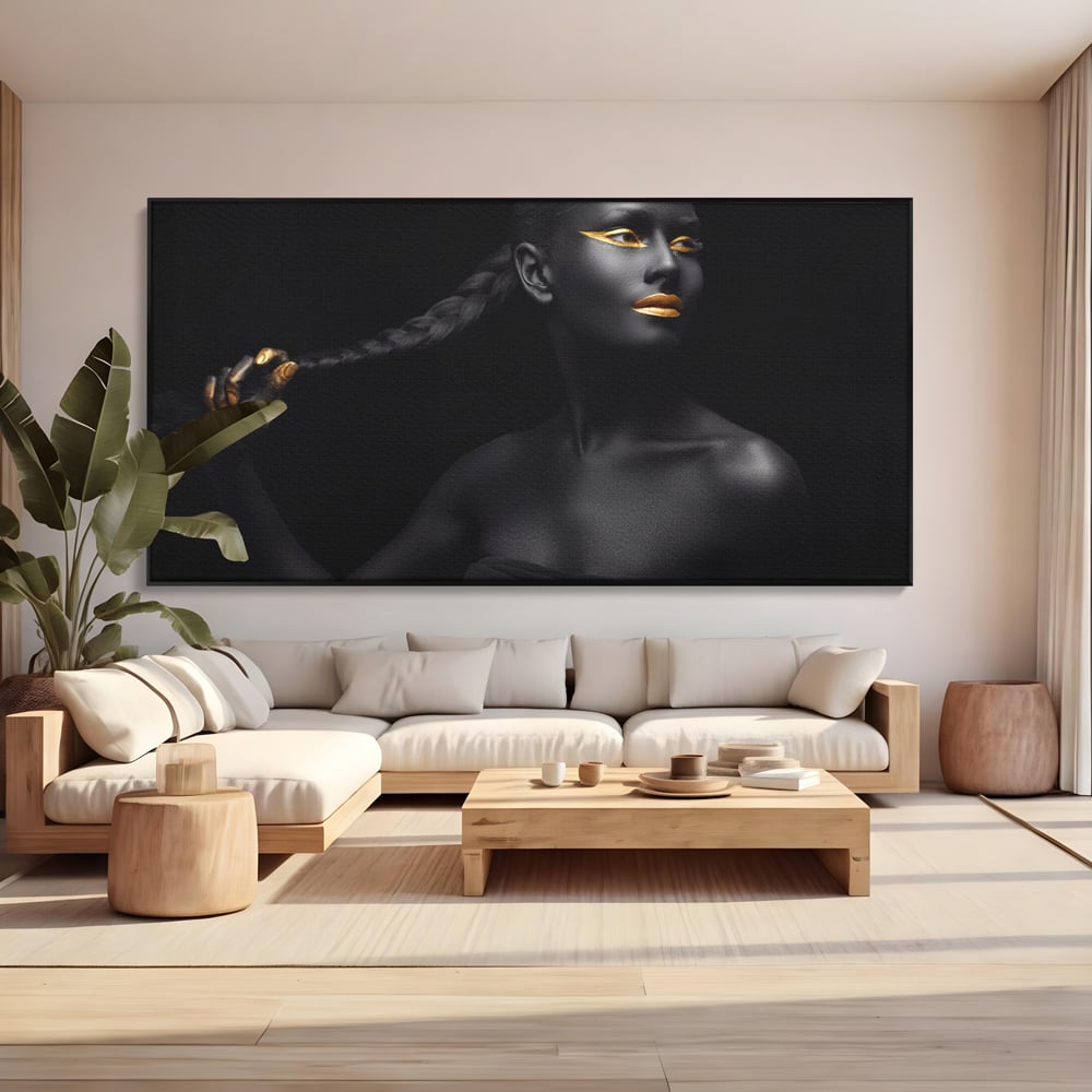 Tablou canvas cu tablou canvas cu femeie vopsita in negru si auriu, in rama de aluminiu negru, pe perete intr-un living
