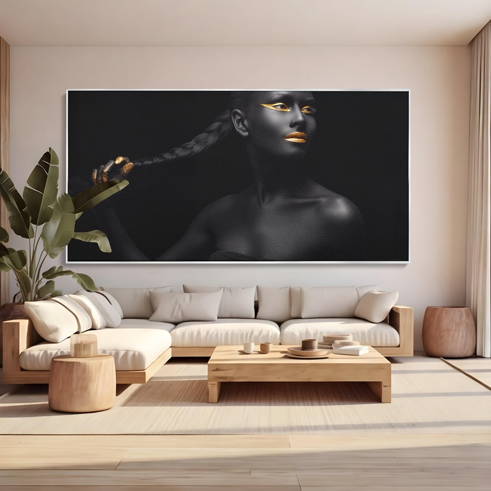 Tablou canvas cu tablou canvas cu femeie vopsita in negru si auriu, in rama de aluminiu argintiu, pe perete intr-un living