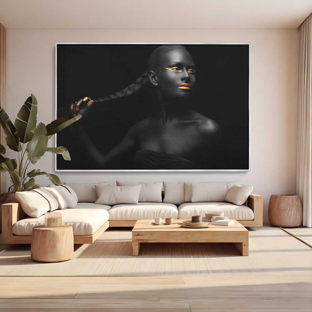 Tablou canvas cu tablou canvas cu femeie vopsita in negru si auriu, in rama de aluminiu argintiu, pe perete intr-un living