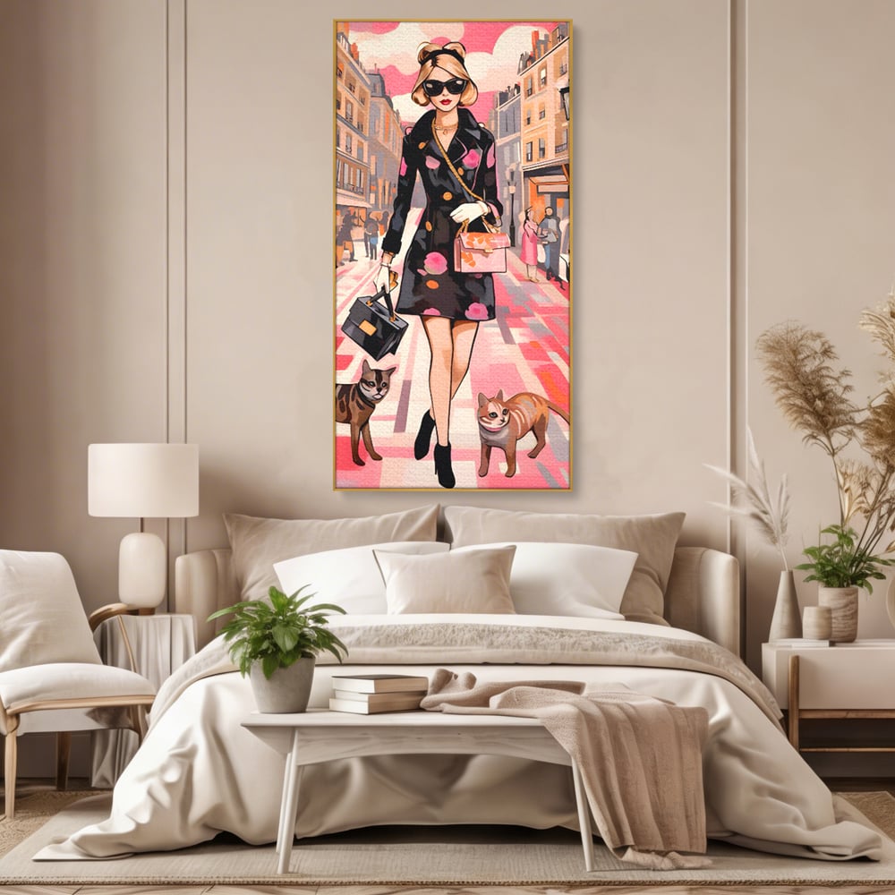 Tablou canvas cu ilustratie fashion cu femeie si pisici, in rama de aluminiu auriu, pe perete intr-un dormitor