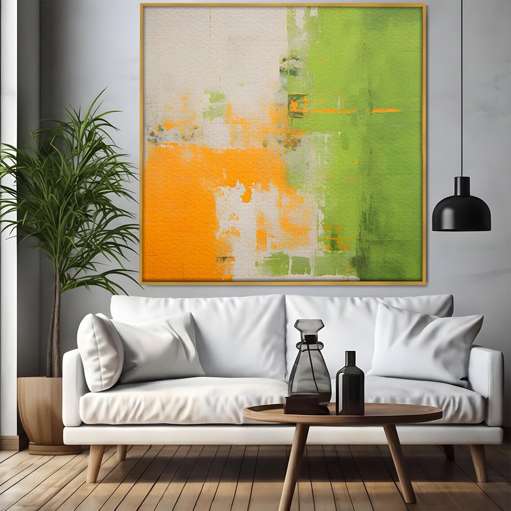 Tablou canvas cu pictura abstracta cu portocaliu si verde, in rama de aluminiu auriu, pe perete intr-un living