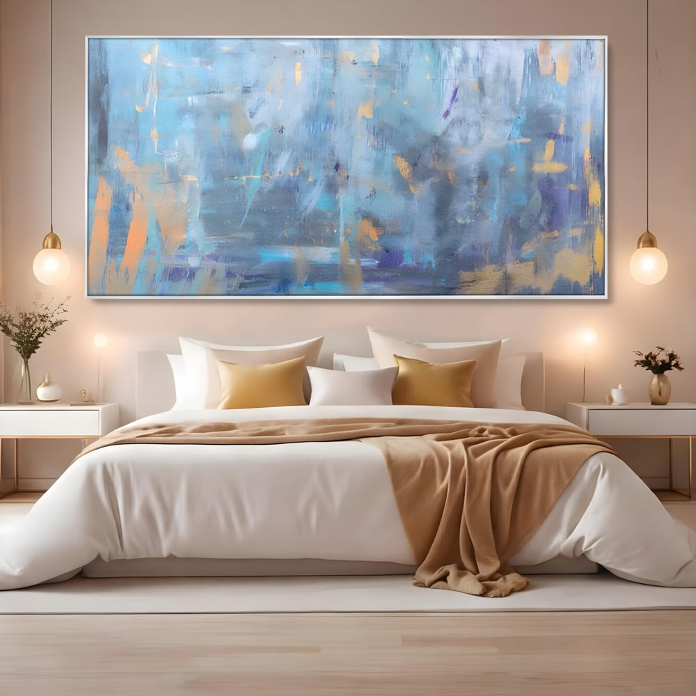 Tablou canvas cu pictura abstracta cu pete aurii si albastre, in rama de aluminiu argintiu, pe perete intr-un dormitor