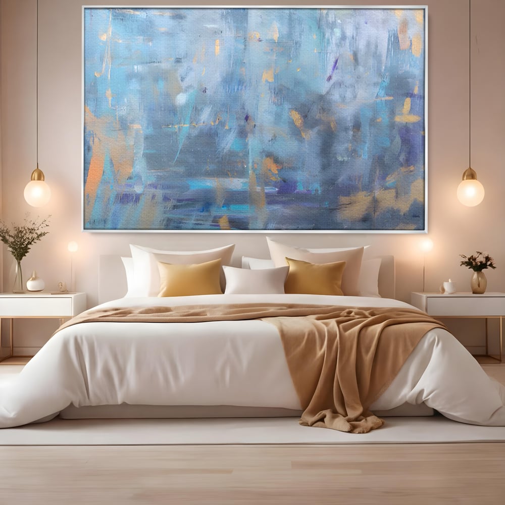 Tablou canvas cu pictura abstracta cu pete aurii si albastre, in rama de aluminiu argintiu, pe perete intr-un dormitor