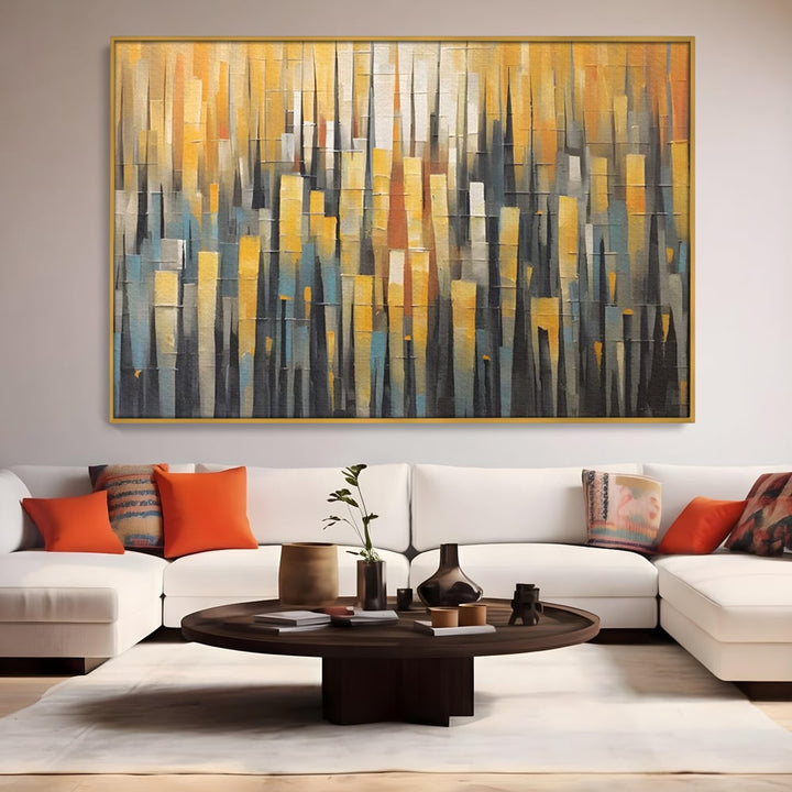 Tablou canvas cu pictura abstracta cu dungi verticale aurii, in rama de aluminiu auriu, pe perete intr-un living