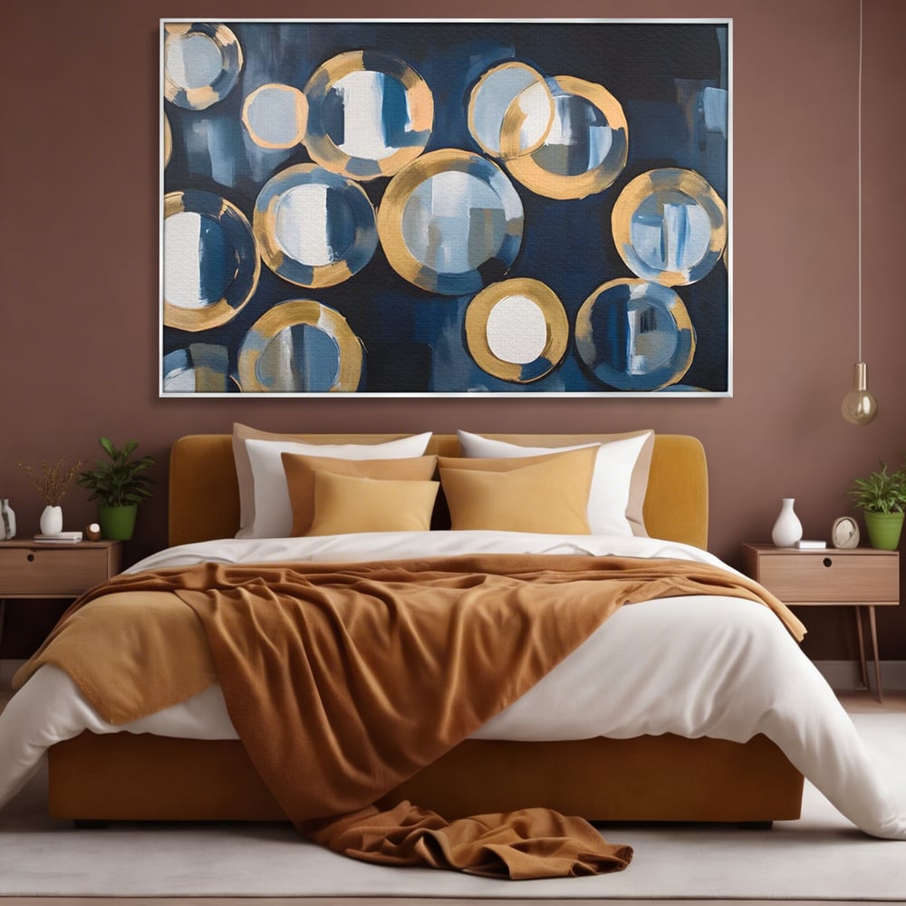 Tablou canvas cu pictura abstracta cu cercuri albastre si aurii, in rama de aluminiu argintiu, pe perete intr-un dormitor