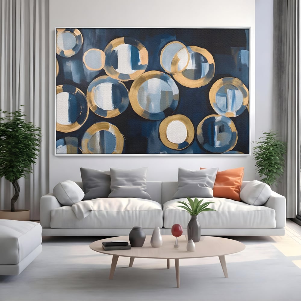Tablou canvas cu pictura abstracta cu cercuri albastre si aurii, in rama de aluminiu argintiu, pe perete intr-un living