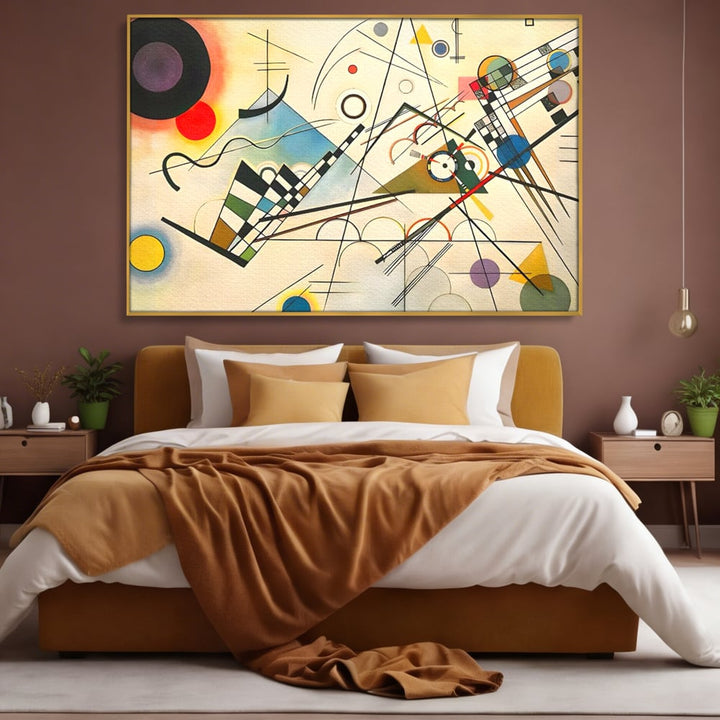 Tablou canvas cu pictura abstracta cu forme geometrice colorate, in rama de aluminiu auriu, pe perete intr-un dormitor