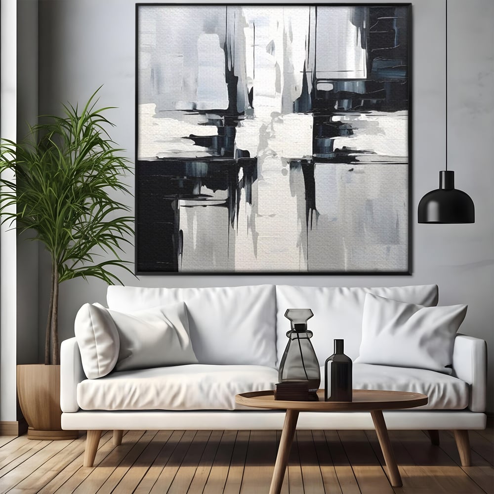 Tablou canvas cu pictura abstracta alb-negru, in rama de aluminiu negru, pe perete intr-un living